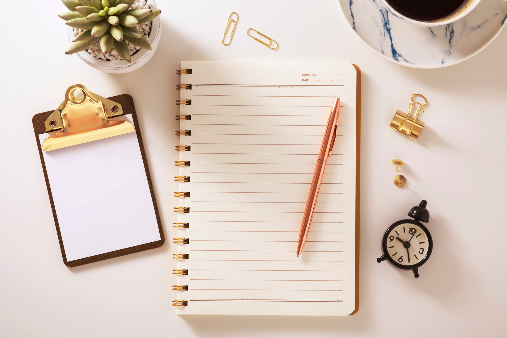 Flat lay desk with notebook and golden accessories